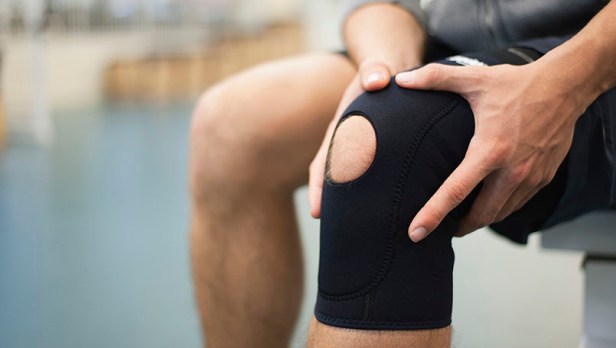 Man wearing knee brace, cropped